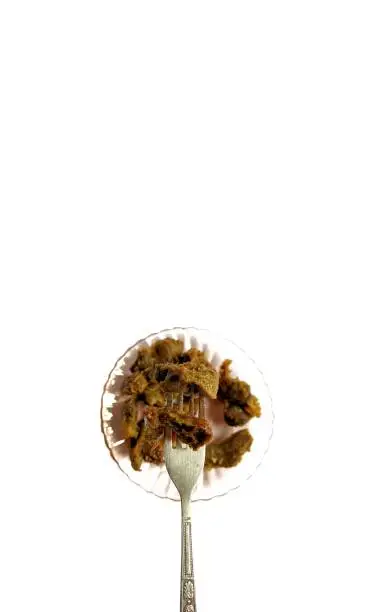 Photo of Fried chicken gizzards on a plate with fork on white background. typical food of Guatemala