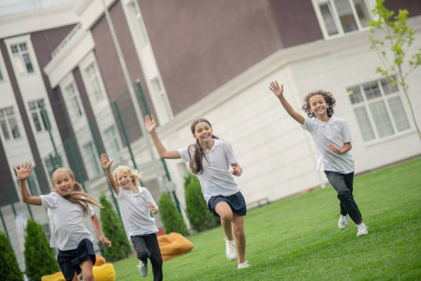 istock Group of teens having a running competition and waving hands 1273342293