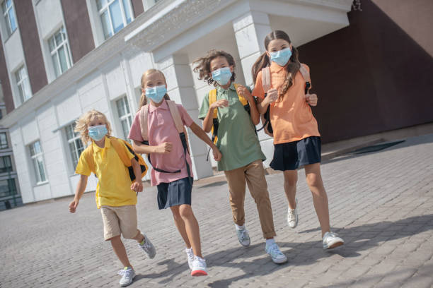 istock Schoolchildren in protective masks on their way home after lessons 1273342332