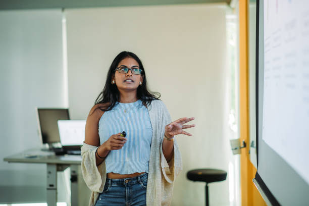 istock Asian indian smiling female student presenting in college classroom 1273343468