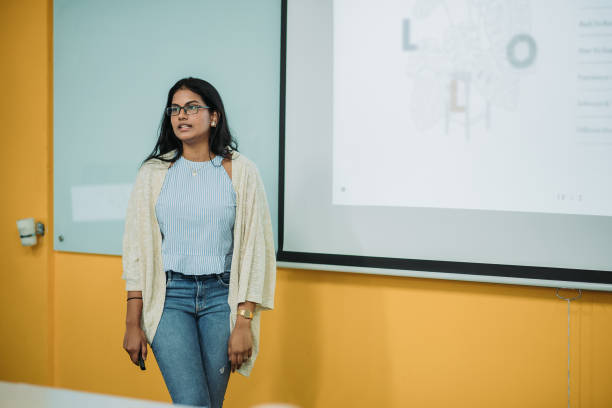 istock Asian indian smiling female student presenting in college classroom 1273343527
