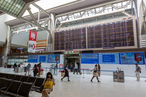 Narita International Airport in Japan People at the departure hall in Narita International Airport, Chiba, Japan. Flights scheduled for departure are listed on a board in the Airport. narita japan stock pictures, royalty-free photos & images