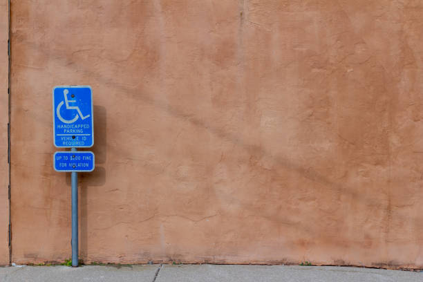istock Reddish brown adobe style wall with handicap parking sign 1273344062