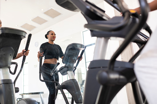 Woman exercising on step machine in gym