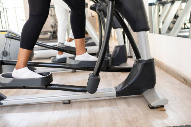 istock Close up womans feet on elliptical training machine 1273345293