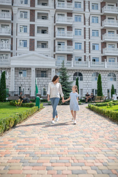 istock Mom and daughter walking and holding hands 1273349291