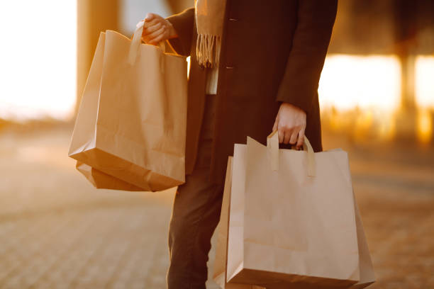 istock Shopping bags in the hands at sunset. 1273349611