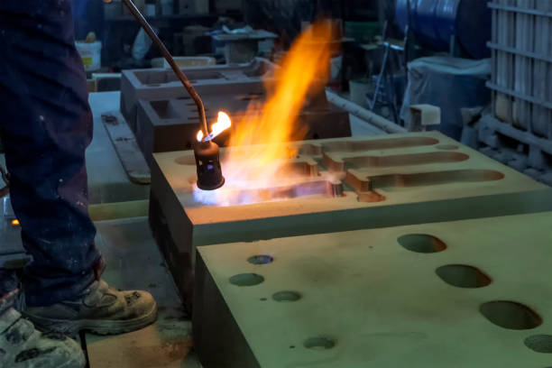 istock The worker is preheating to mold for casting.  Sand casting, also known as sand molded casting, is a metal casting process characterized by using sand as the mold material. 1273350482