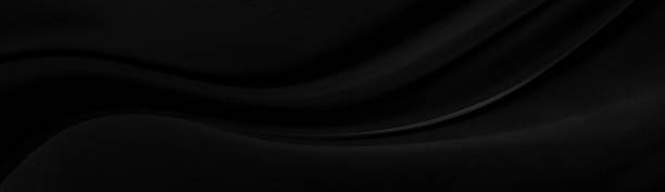istock Black gray satin dark fabric texture luxurious shiny that is abstract silk cloth panorama background with patterns soft waves blur beautiful. 1273350495