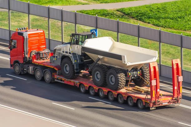 a large truck transporting a dump truck on the highway