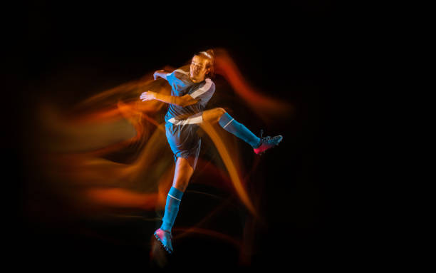 istock Football or soccer player on black background in mixed light, fire shadows 1273351255