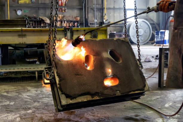 istock The worker is preheating to mold for casting.  Sand casting, also known as sand molded casting, is a metal casting process characterized by using sand as the mold material. 1273352662
