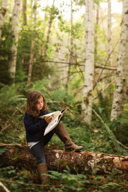 istock Girl reading book on log 1273353613