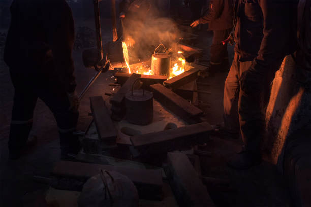 istock The workers are pouring molten metal to molds for casting. Casting is a manufacturing process in which a liquid material is usually poured into a mold. 1273353775