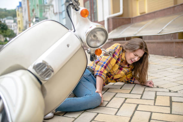 istock Woman having her knee injured while falling from a scooter 1273354088