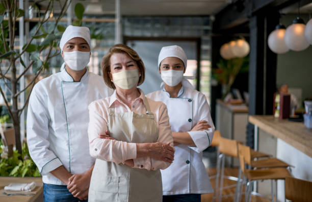 istock Staff working at a restaurant wearing facemasks during the pandemic 1273354279