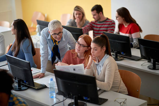 istock Students asking female professor for help at an informatics lecture 1273356526