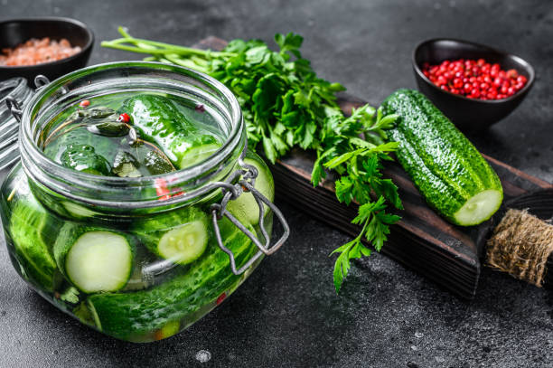 istock Green salted cucumbers. Canned vegetables. Black background. Top view 1273358306