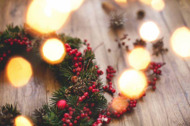 istock Christmas wreath decorations close up on rustic wood in lights. 1273361775