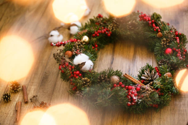 istock Christmas wreath on wooden rustic background in lights 1273362635