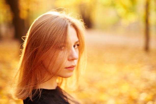 istock Student girl looking to camera with autumn background 1273364048