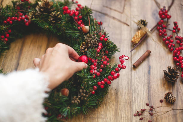 istock Person making traditional christmas wreath on rustic wooden background. 1273364166