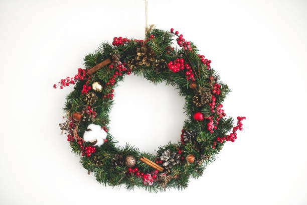 istock Christmas wreath hanging on white wall in house 1273364966