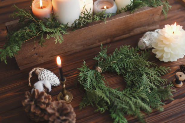 istock Rustic christmas wreath with candles, pine cones, thread and ornaments on wooden table. 1273367188