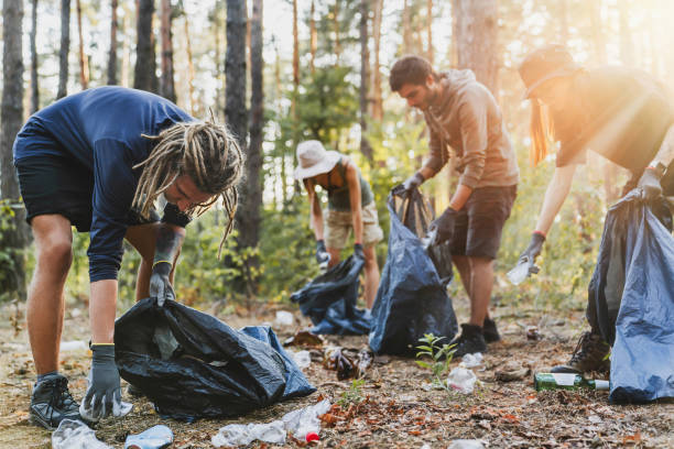 istock Young men and women picking up litter in forest 1273367546