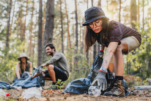 istock Active young woman with hat cleaning forest in plastic bag, ecology helping environment garbage concept 1273367918