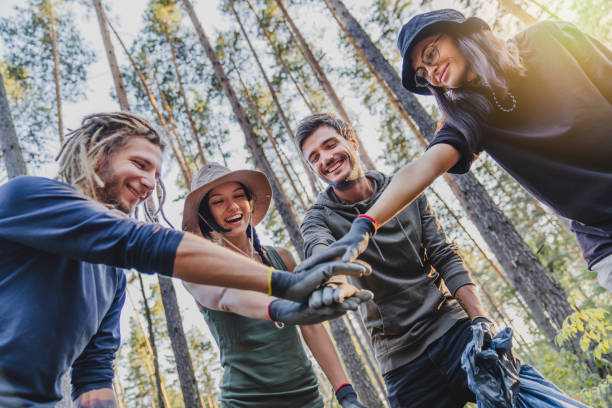 istock Teamwork concept. Group of friends during collecting trash in forest 1273367953