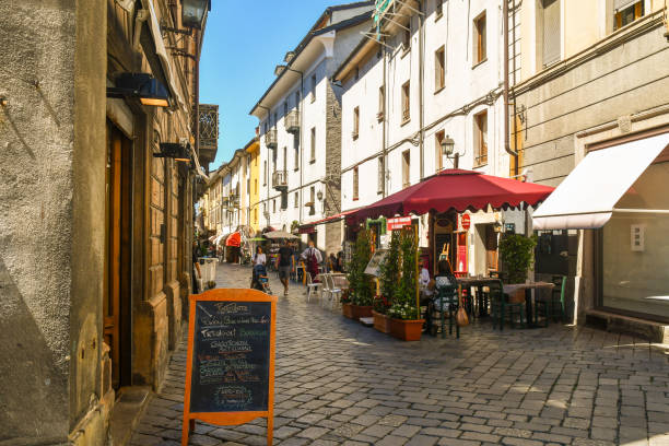 vista de rua no centro histórico da antiga cidade alpina com restaurantes ao ar livre e turistas no verão, aosta, vale de aosta, itália - valle daosta - fotografias e filmes do acervo