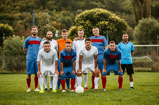 Soccer players posing together for photographing before the match. Fair play.