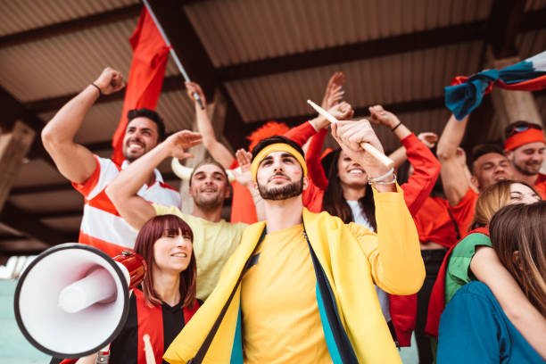 istock friends cheering at the stadium with megaphone 1273372126