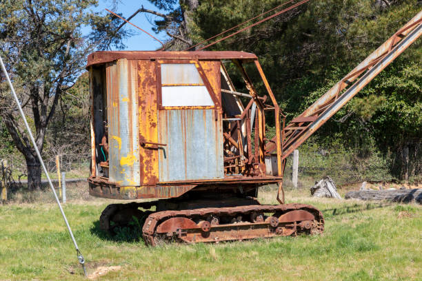 An old rusty crane sitting idle in a green field in regional Australia