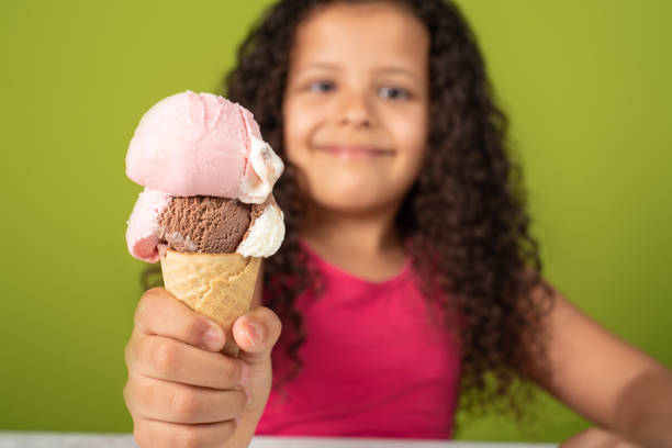 istock Happy child with two scoops of ice cream cone with green background, selective focus. 1273375211
