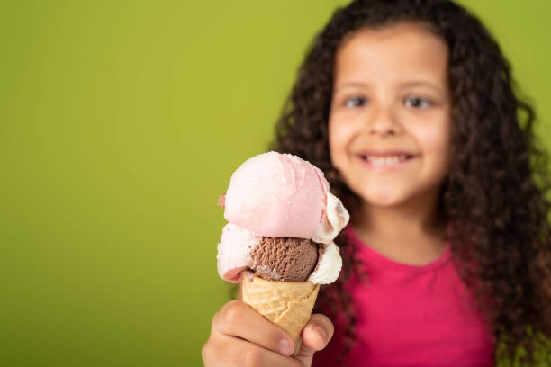 istock Happy child with two scoops of ice cream cone with green background, selective focus. 1273375234