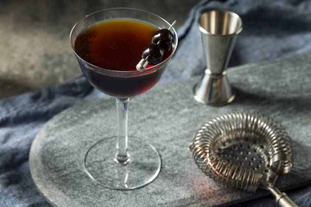 erfrischender boozy black manhattan cocktail - black cherries stock-fotos und bilder