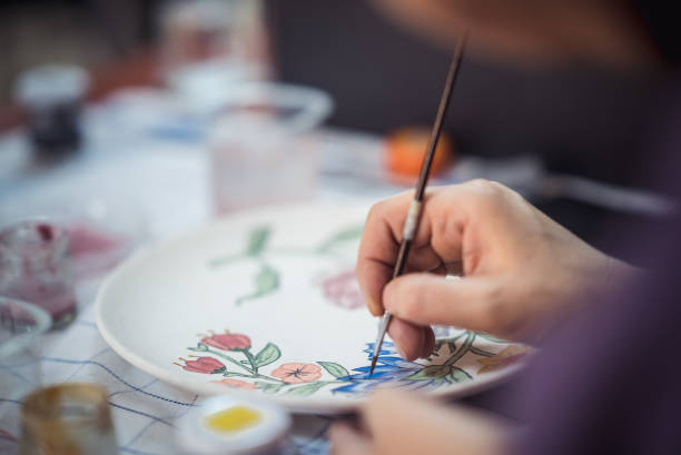 istock Painting flowers on a ceramic plate with a paintbrush 1273381679