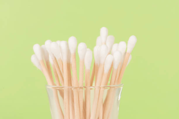 Bamboo cotton buds on wooden background. Zero waste concept. Organic ear sticks on white background.