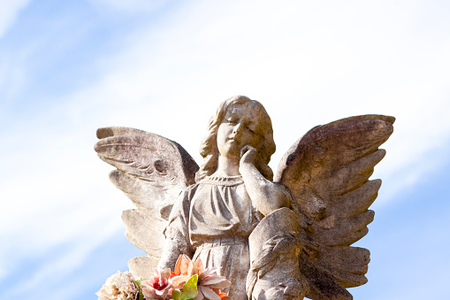 Old statue of girl angle with hand on chin\n in cemetery build in 1877 Sydney Australia, sky background with copy space, horizontal composition
