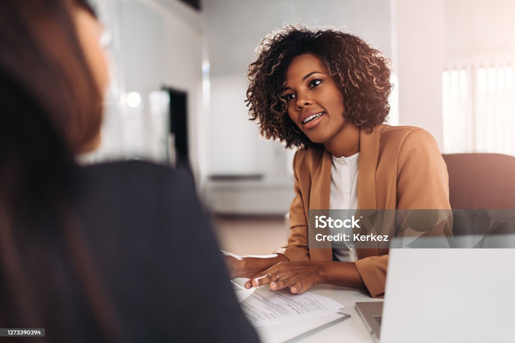 Young woman doing a job interview Young woman doing a job interview in the office and talking with client Job Interview Stock Photo