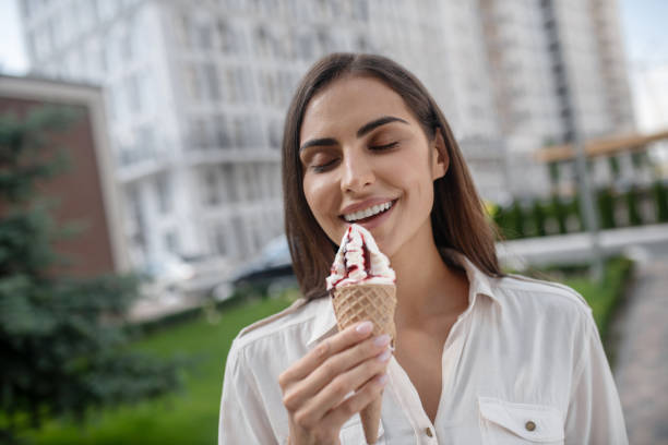 istock Beautiful woman holding ice-cream and looking joyful 1273390802