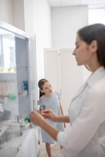 istock Pretty doctor in a lab coat opening a vitrine with medicines 1273390865