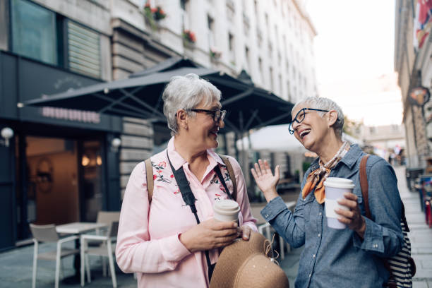 istock Two senior friends on vacation drinking coffee on the move and enjoying 1273391773