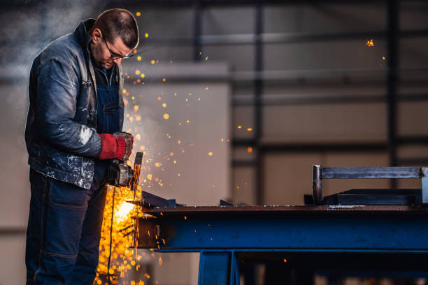 istock Factory worker cutting metal with grinder. 1273393582
