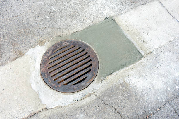 istock Round storm drain grate over just repaired manhole on the road 1273394300