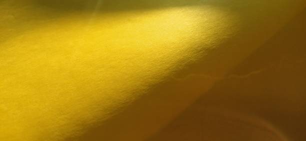 istock The paper or fabric material is bright yellow. Close-up. Slightly folded sheet. Light gradient and accentuated rough surface texture. Background or product sample. Sunny cheerful yellow 1273400454