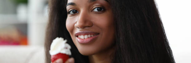 istock Dark-skinned girl holds strawberries with cream 1273400502