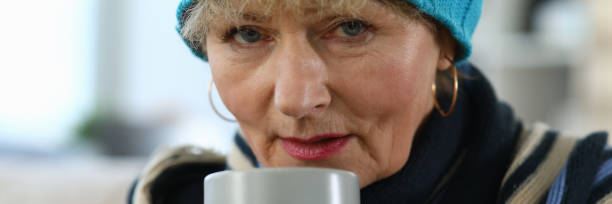 istock Elderly woman feels sick and drinks tea at home 1273400523